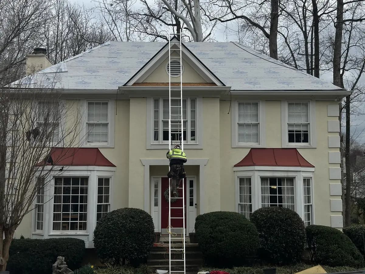 Faith Guard Roofing crew member climbing a ladder onto a roof