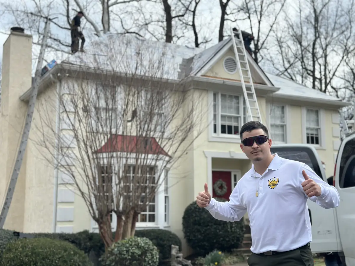 Faith Guard Roofing owner in front of a home while the crew works on the roof