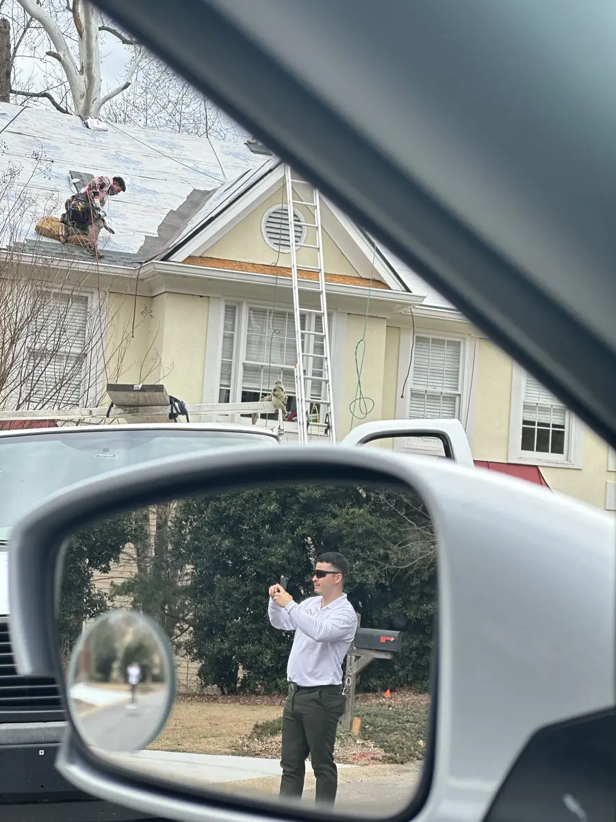 Faith Guard Roofing owner documenting roof edge and gutter work