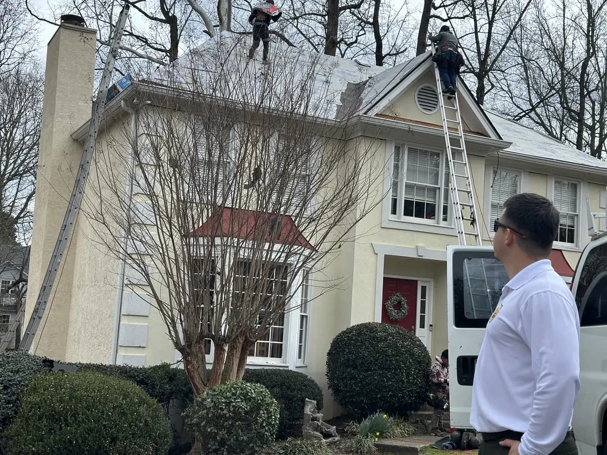 Faith Guard Roofing owner supervising roof work on a two-story home
